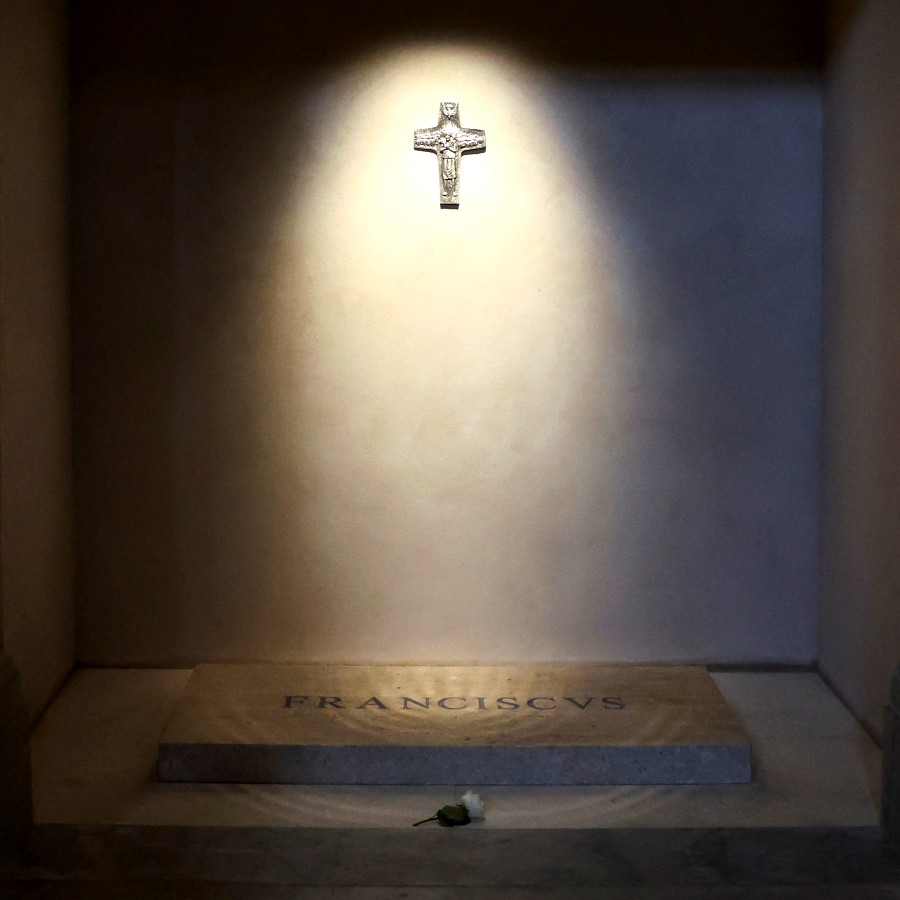 A flower is placed at tomb of the late Pope Francis in the Papal Basilica of Saint Mary Major, spot-lit from above