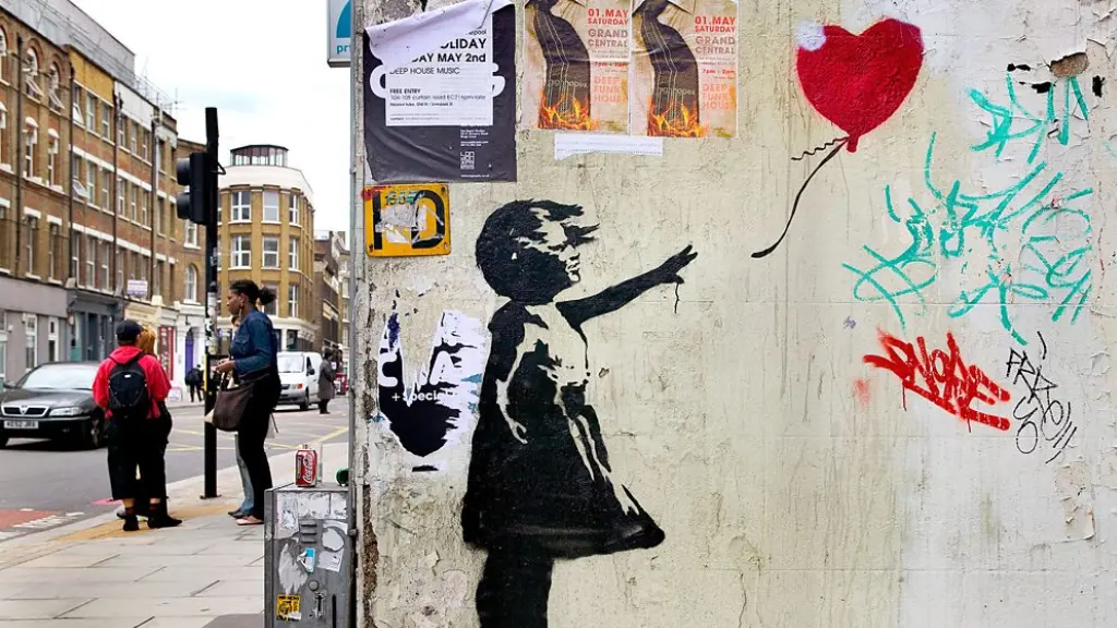 A man taking a photo of Banksy's new mural Lighthouse in Marseille, with text that reads "I want to be what you saw in me" (Credit: Photo of Lighthouse, 2025/ Alamy)