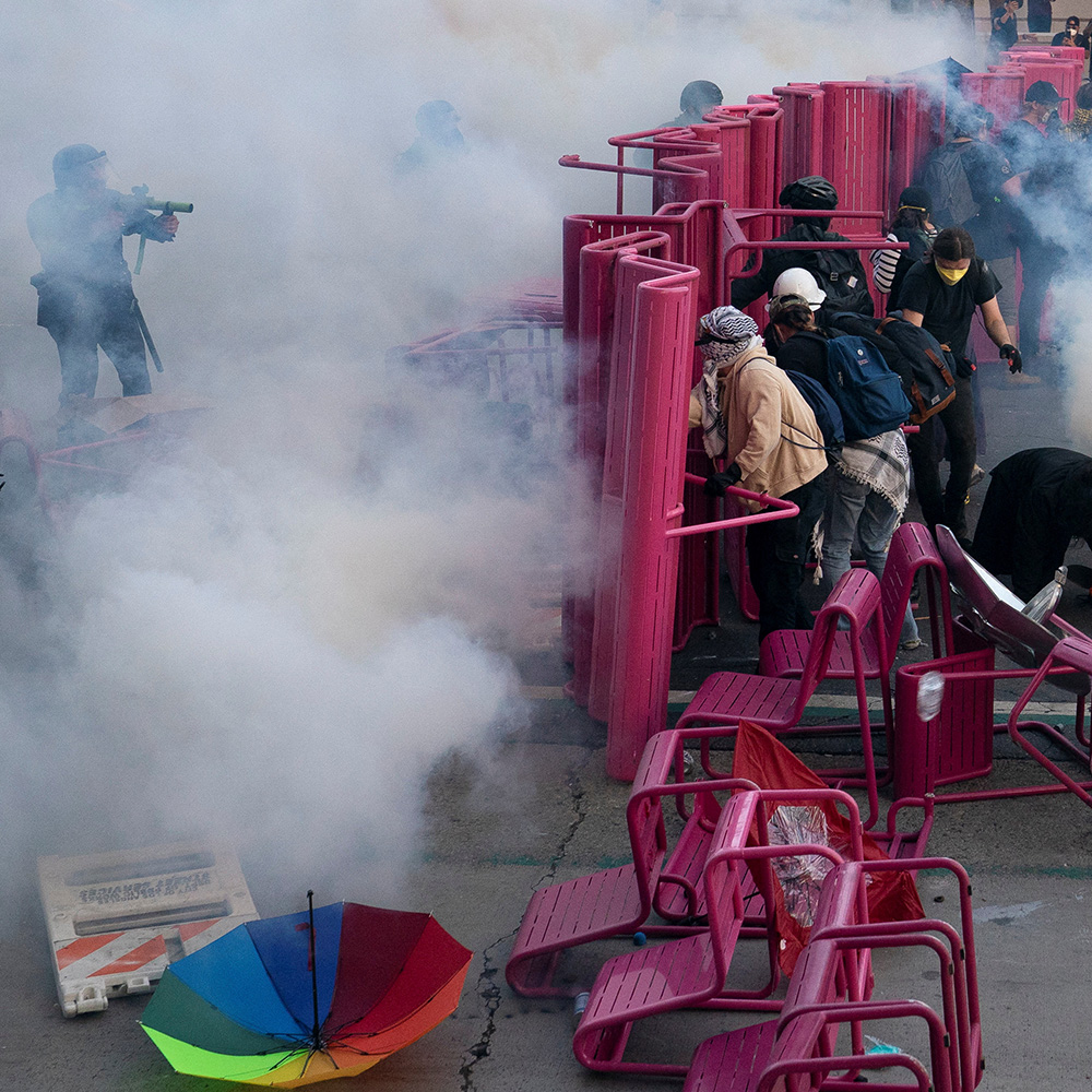 Police clear demonstrators after they blocked a street with a barricade