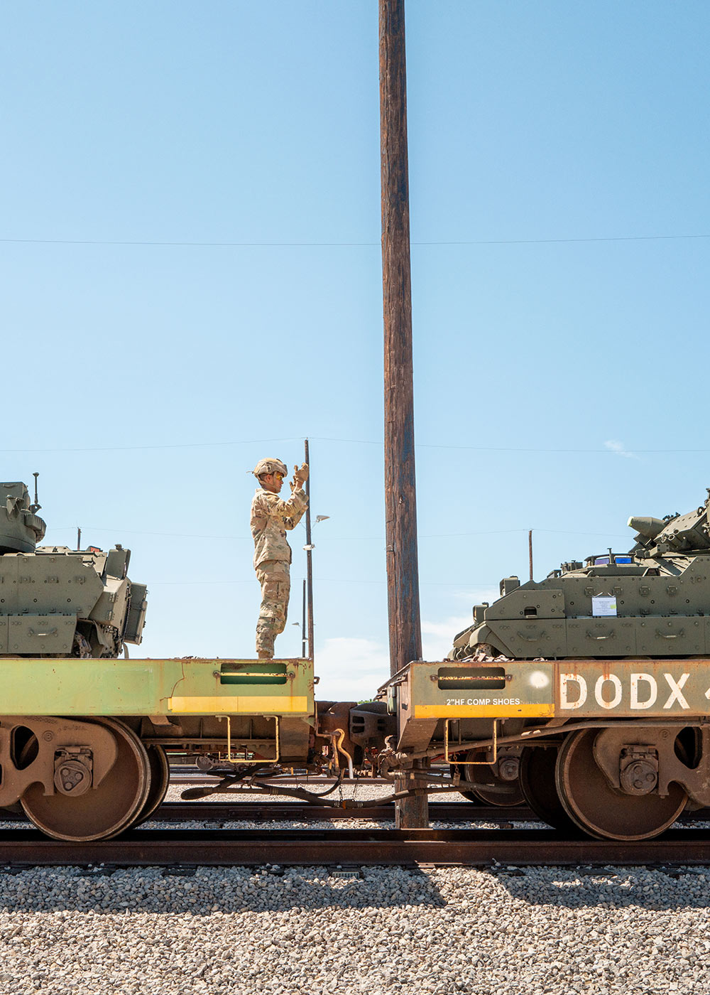 A US Army soldier gives direction as a tank is loaded onto a train en route to Washington DC from Fort Cavazos in Killeen, Texas