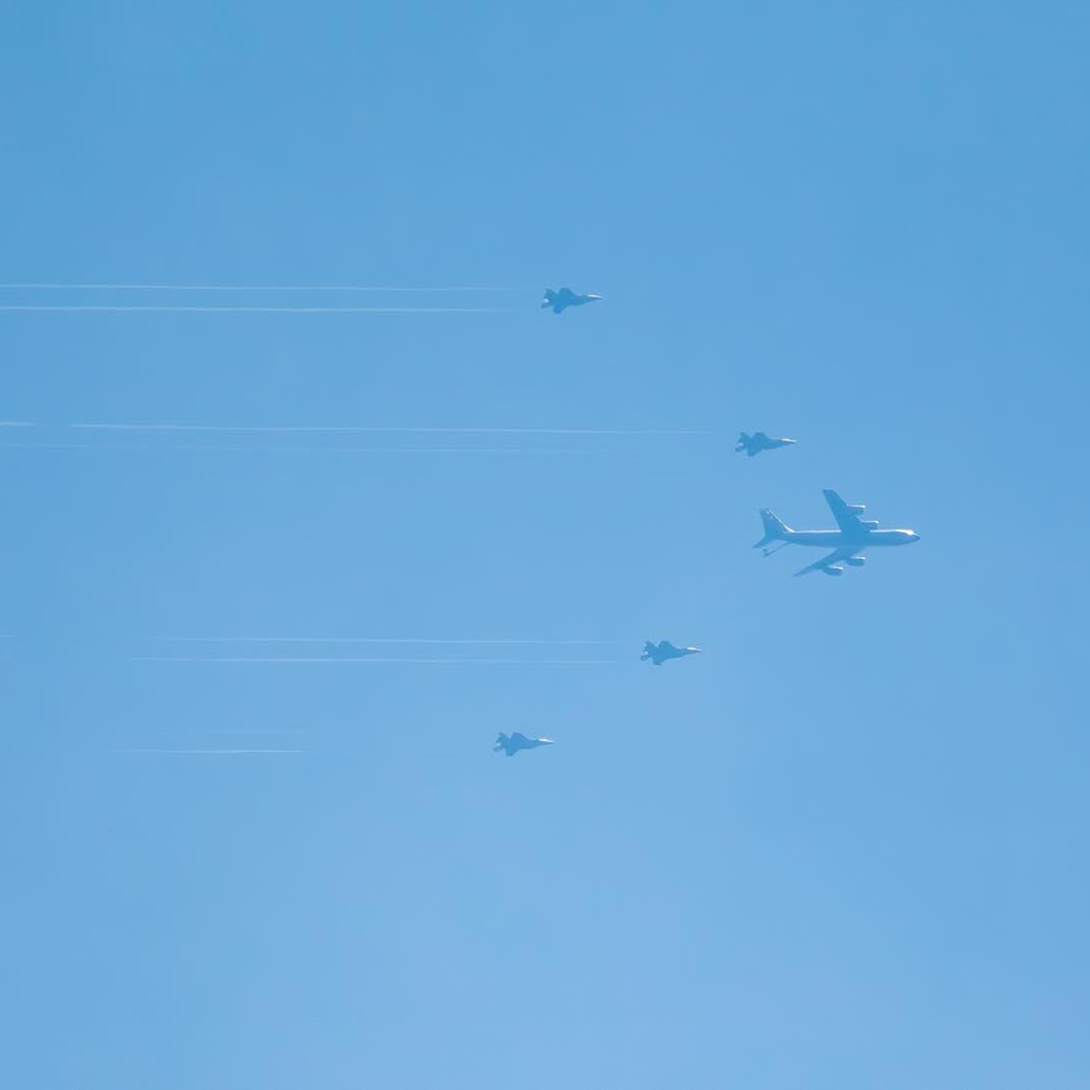 A photograph showing four US fighter jets flying alongside a KC-135 refuelling tanker aircraft in the skies over Suffolk, England