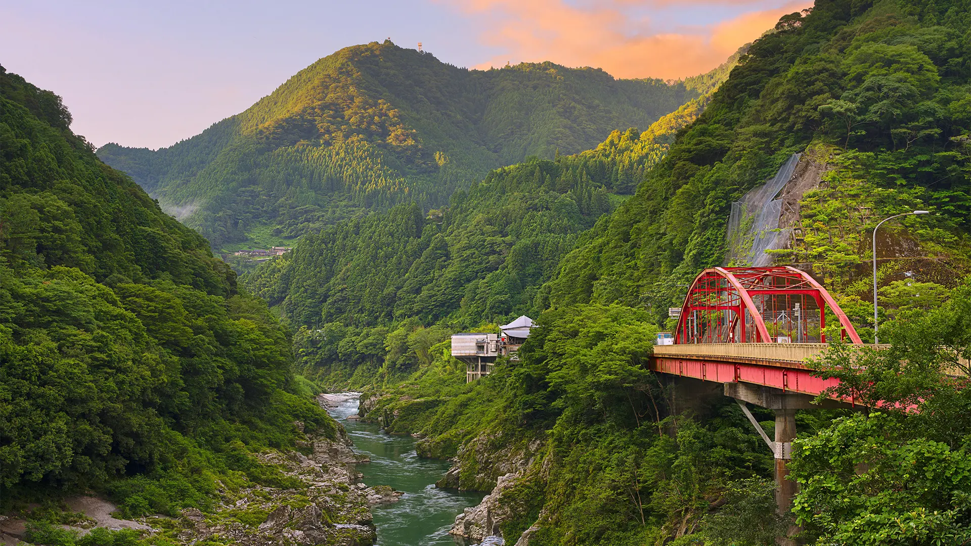 An outdoor walkway at a Japanese village school with a misty forest to the side (Credit: Hare to Ke)