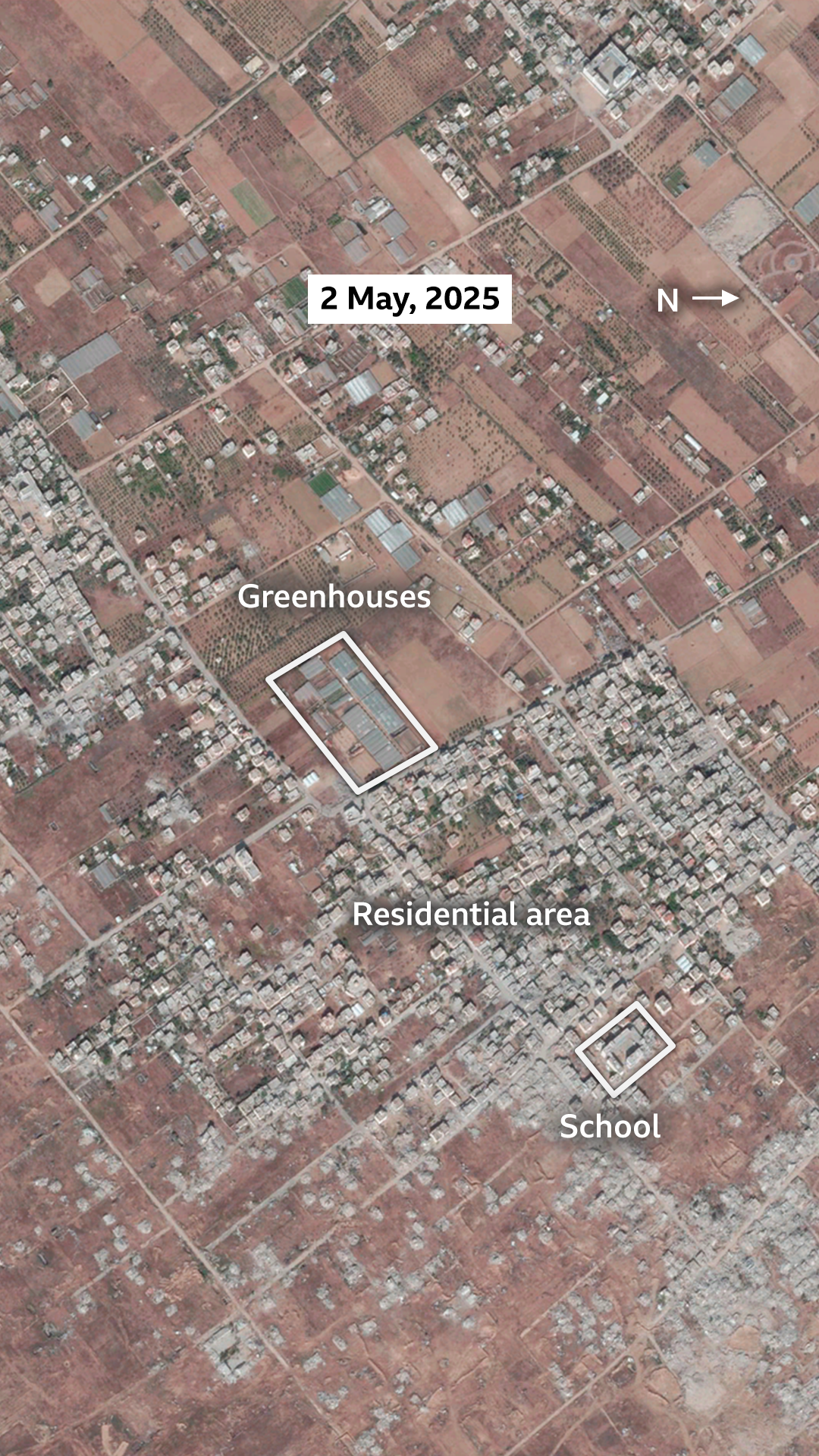A satellite image of Khuza'a on 2 May, 2025. The area with the majority of the buildings is labelled as the main settlement. A smaller area is labelled as greenhouses