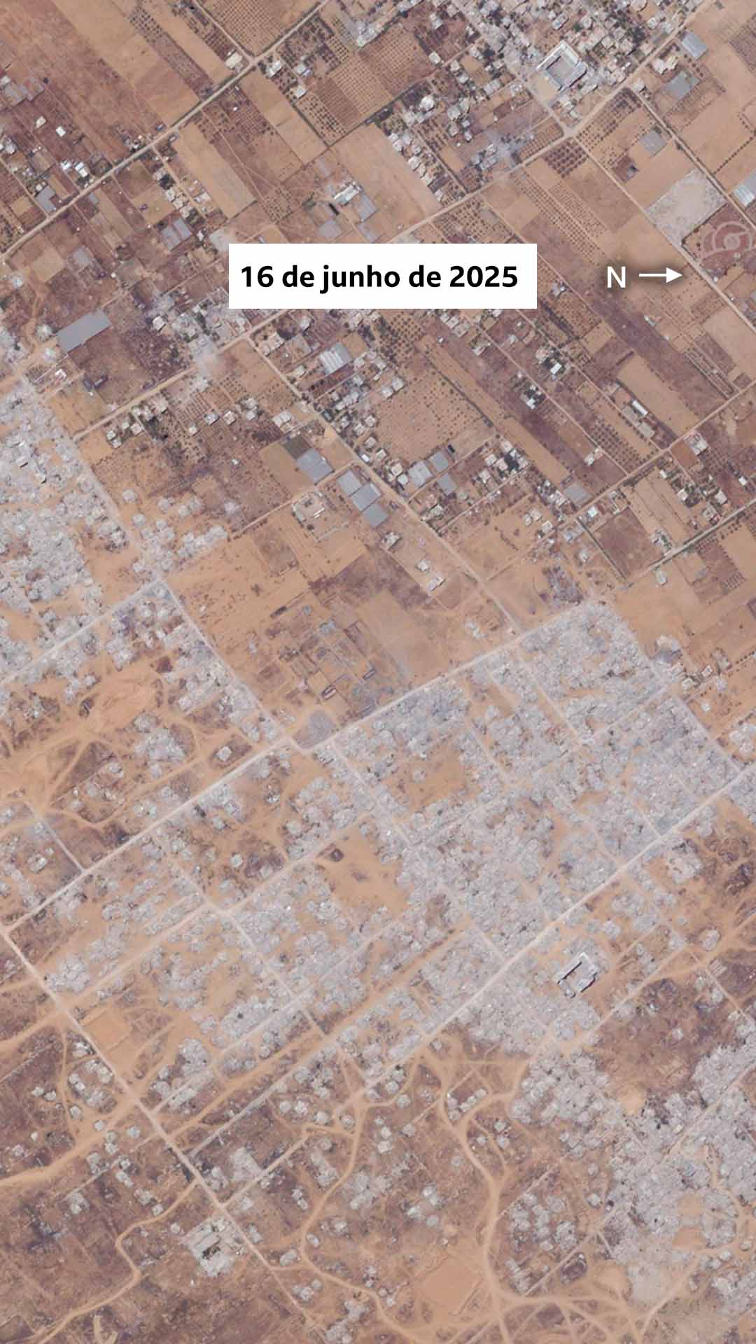 Uma imagem de satélite de Khuza'a em 16 de junho de 2025. A imagem mostra que a maioria dos edifícios do assentamento, as estufas e a maior parte da vegetação foram destruídos.