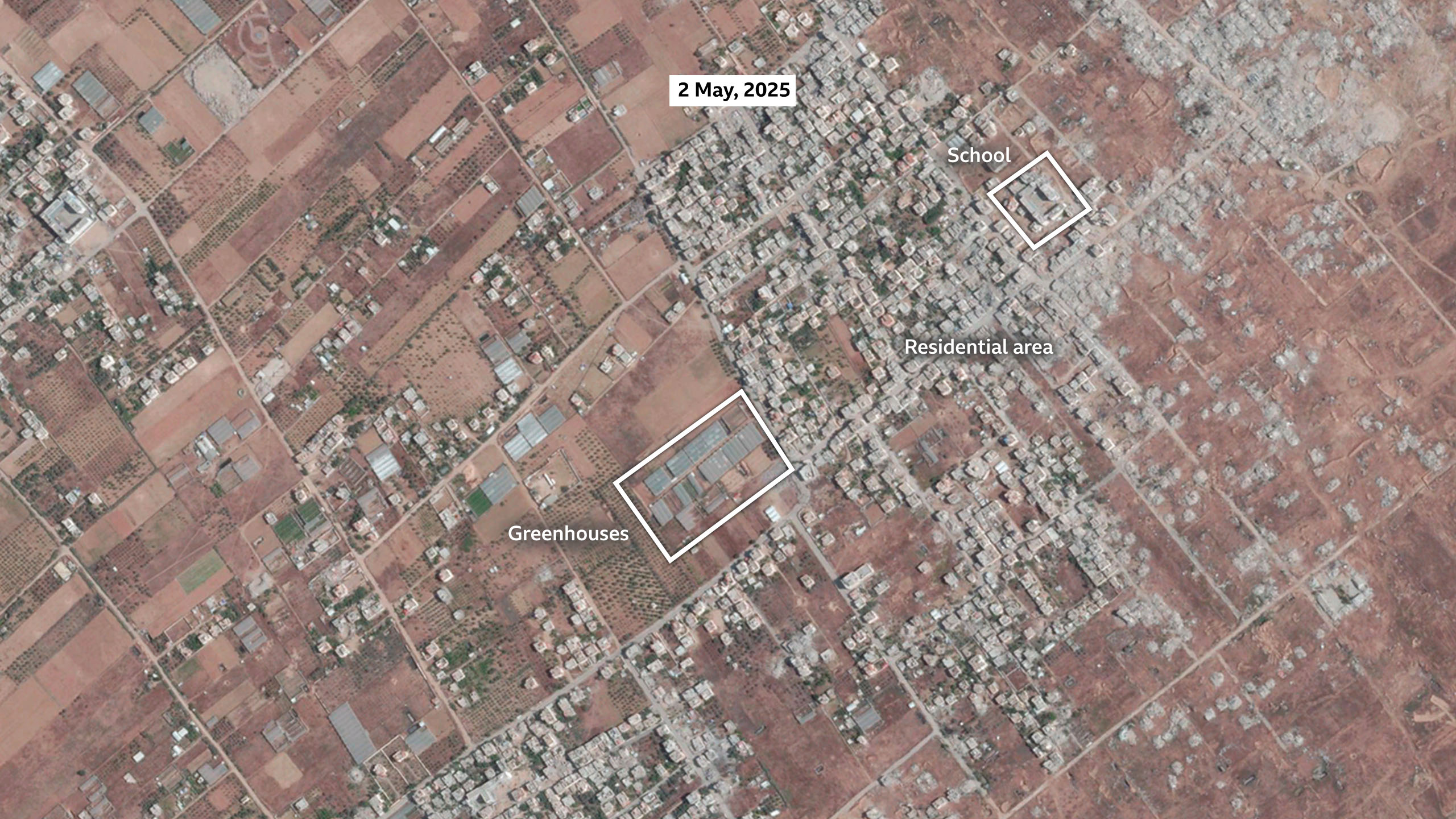A satellite image of Khuza'a on 2 May, 2025. The area with the majority of the buildings is labelled as the main settlement. A smaller area is labelled as greenhouses