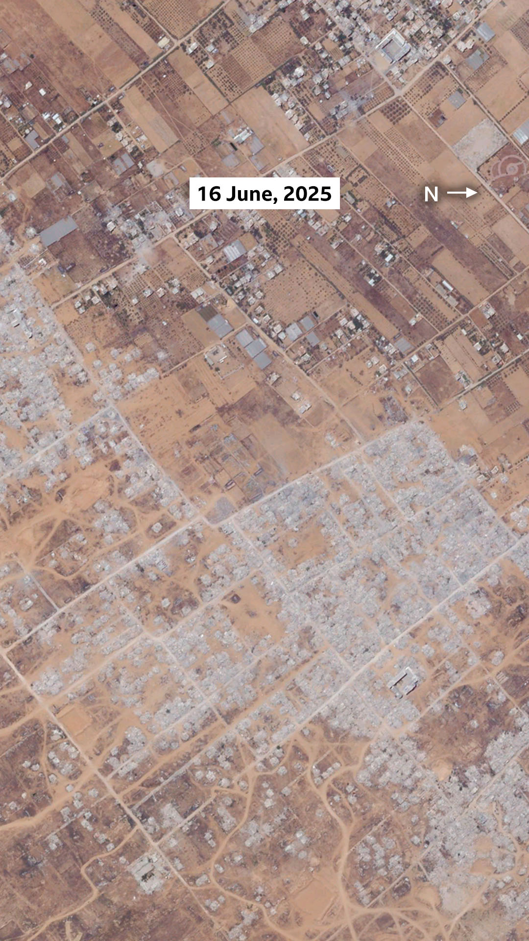 A satellite image of Khuza'a on 16 June, 2025. The image shows that most of the buildings in the settlement, the greenhouses, and most of the vegetation has been destroyed.