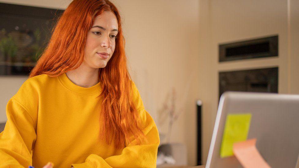 A female student sitting in front of a laptop