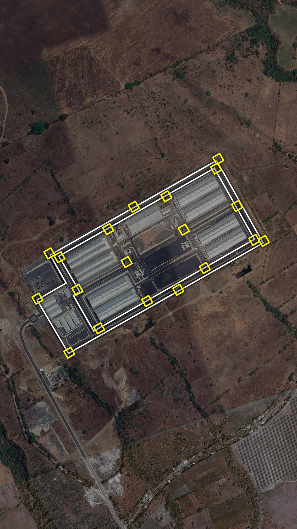 Aerial image of the Cecot prison with the perimeter walls highlighted in white lines and the watchtowers in yellow squares