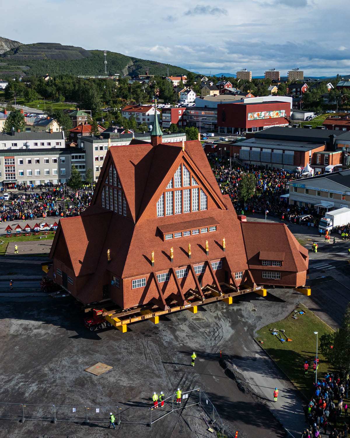 An aerial shot of the church surrounded by crouwds with Kiruna in the background