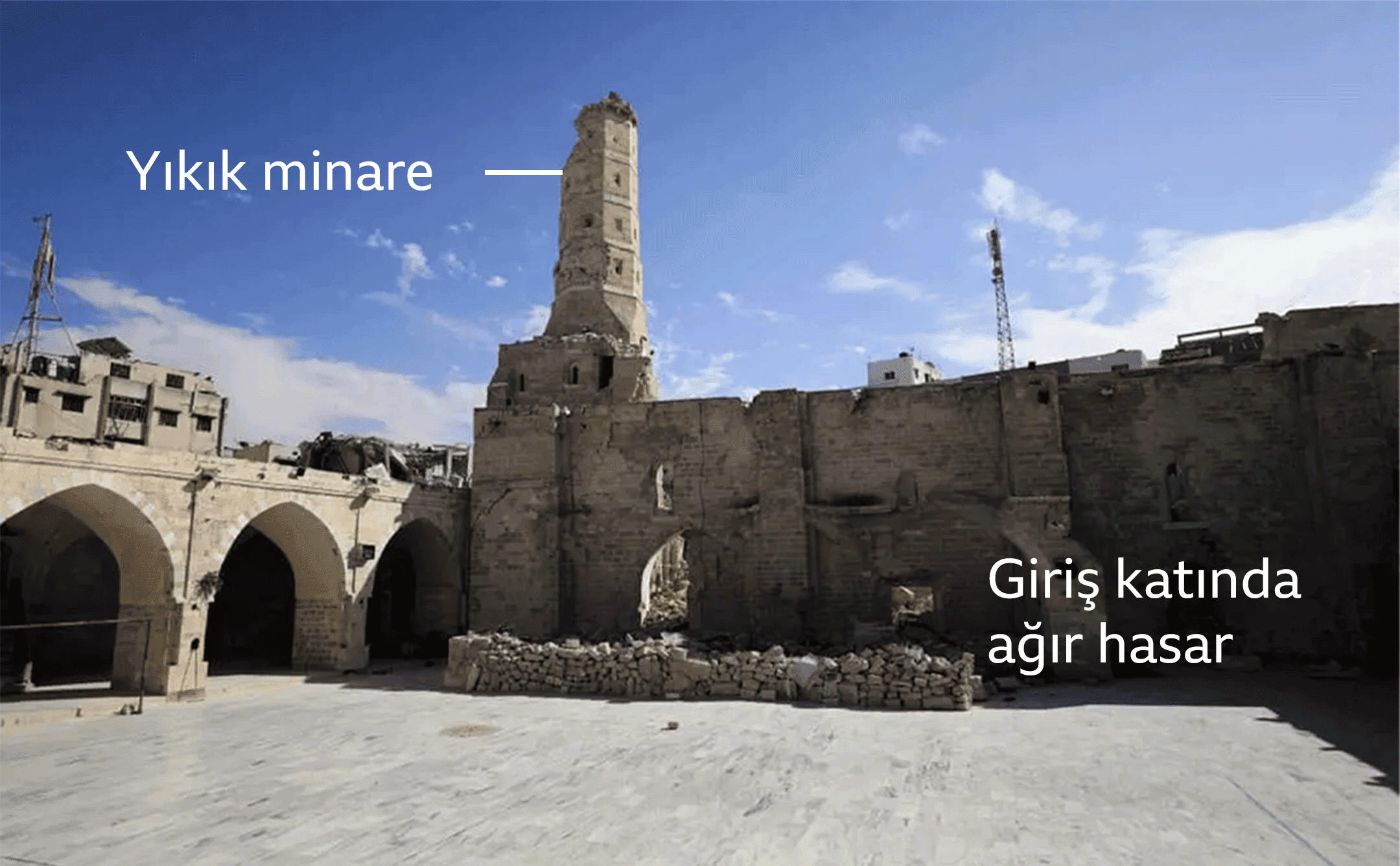 Ağustos 2024'te Büyük Ömer Cami'nin avlusu. Yazılarda hasar görmüş minare ve ağır hasar almış giriş katı görülüyor. 