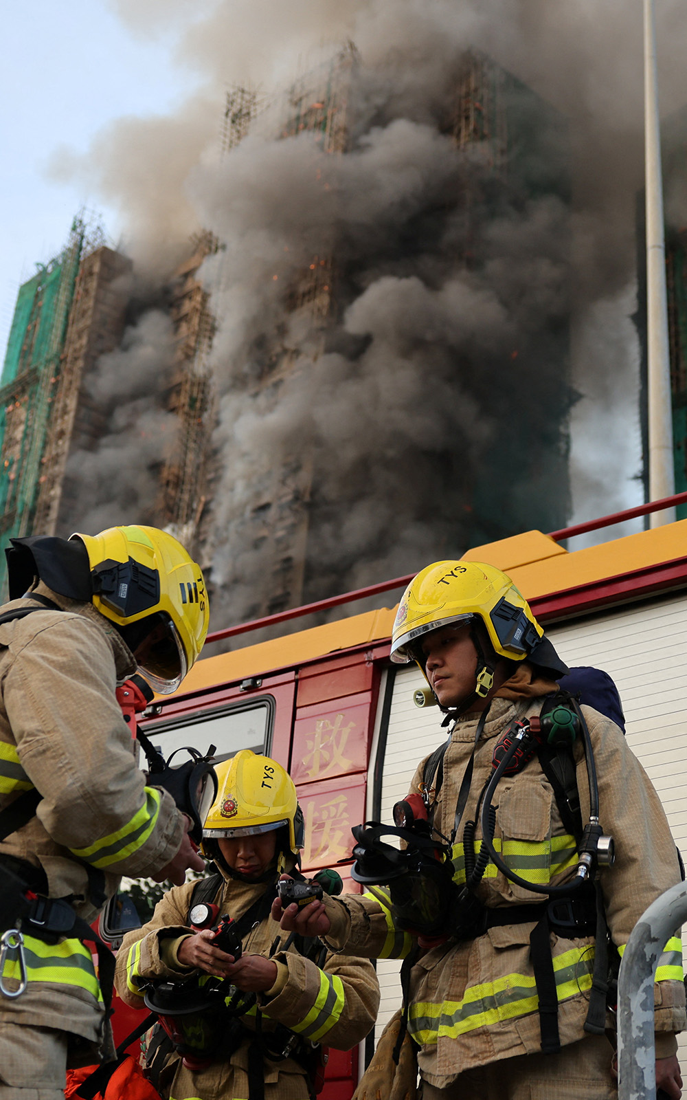 Firefighters work as efforts are underway to extinguish flames engulfing bamboo scaffolding across multiple buildings at the Wang Fuk Court housing estate in Tai Po, Hong Kong, China, November 26