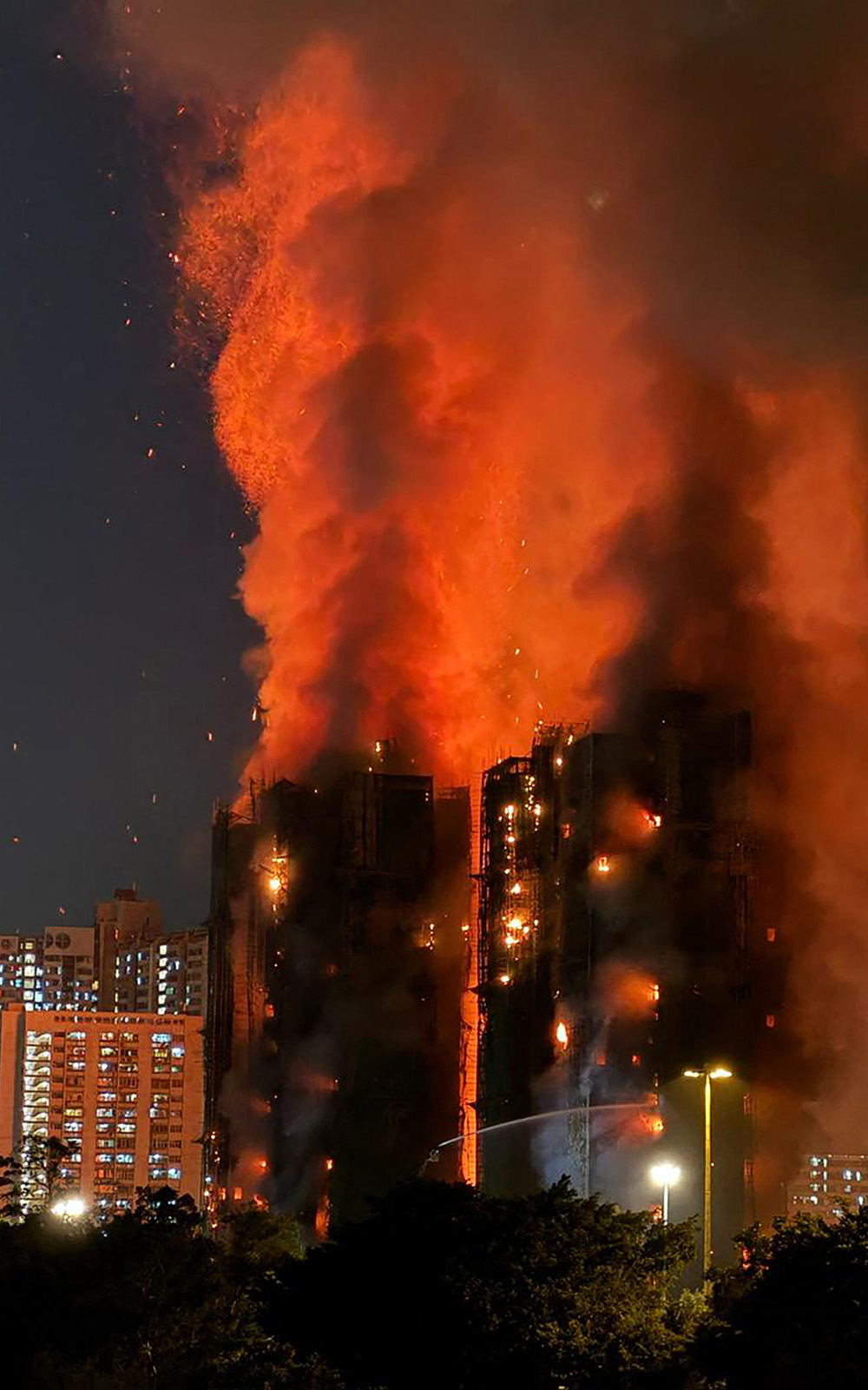 Thick smoke and flames rise as a major fire engulfs several apartment blocks at the Wang Fuk Court residential estate in Hong Kong's Tai Po district on November 26, 2025