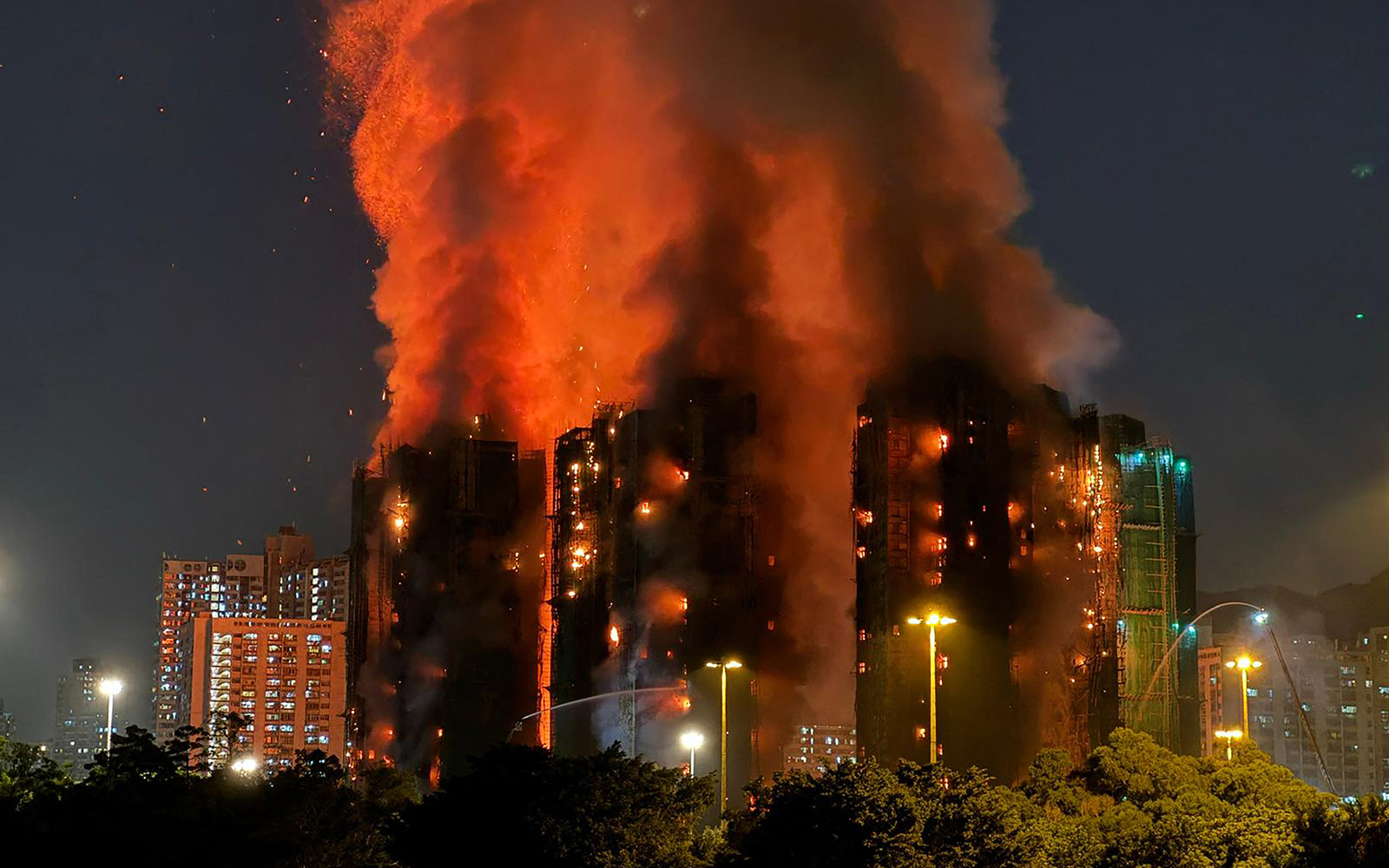 Thick smoke and flames rise as a major fire engulfs several apartment blocks at the Wang Fuk Court residential estate in Hong Kong's Tai Po district on November 26, 2025