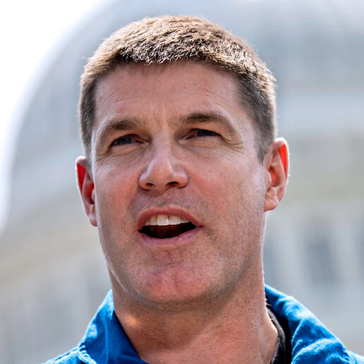 A headshot of Jeremy Hansen with short cropped hair, caught in mid conversation his mouth open with a slightly wry look on his face.