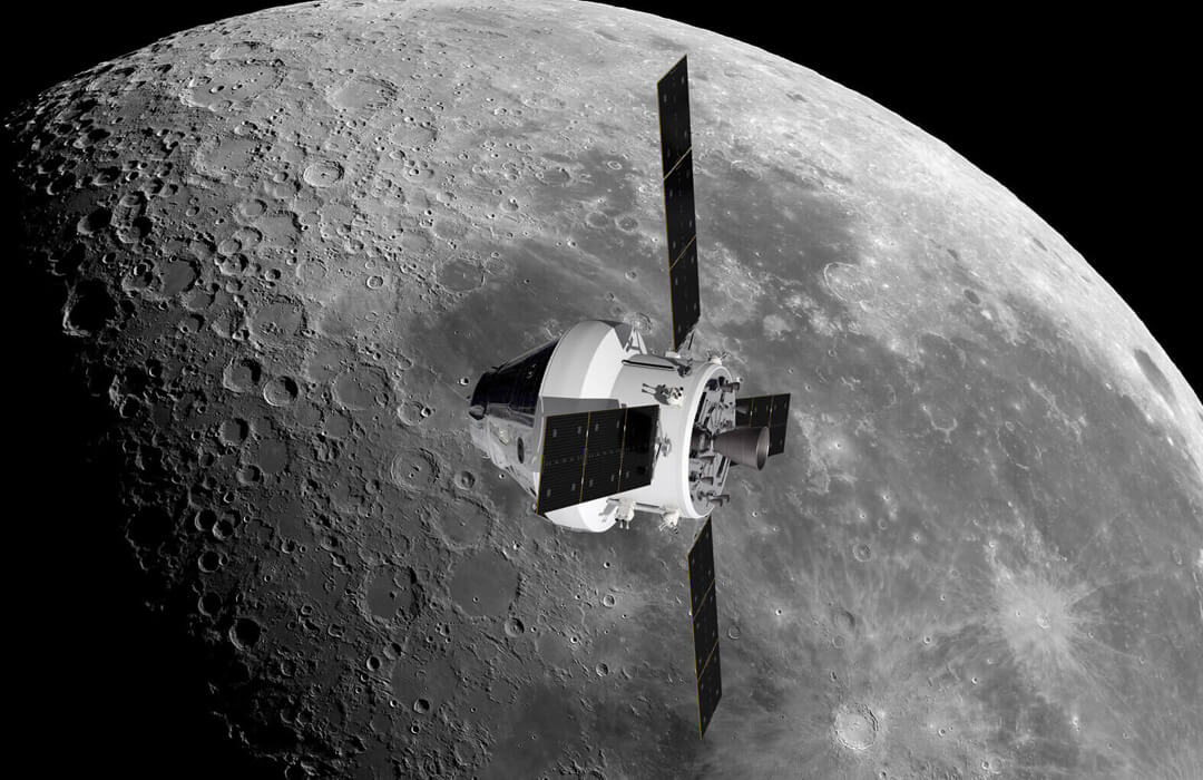 Computer-generate image of Orion orbiting the Moon. Orion has its four solar arrays extended in a cross and is sideways to the Moon itself which is shown behind with the light from the Sun coming from the right and casting deep shadows in the craters on the surface. The left side of the Moon - where Orion is heading - falls into complete darkness.