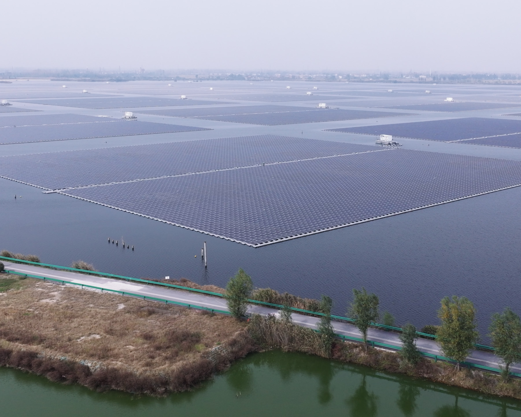 大片漂浮式太陽能板覆蓋湖面,向遠方延展,形成網格狀排列。