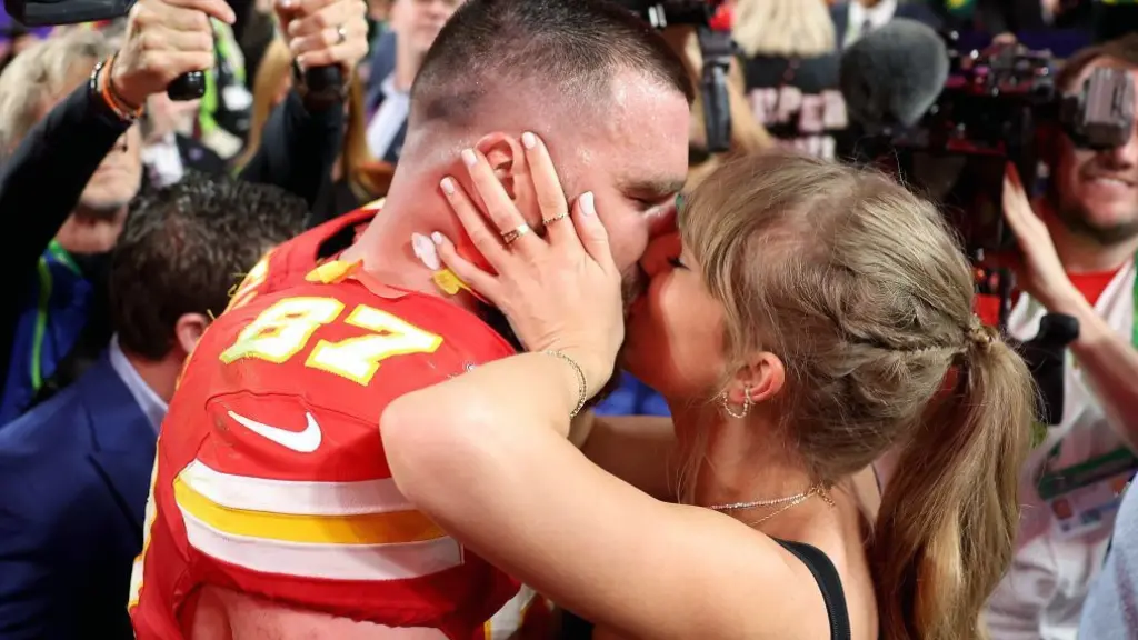 Travis Kelce of the Kansas City Chiefs kisses Swift after a game