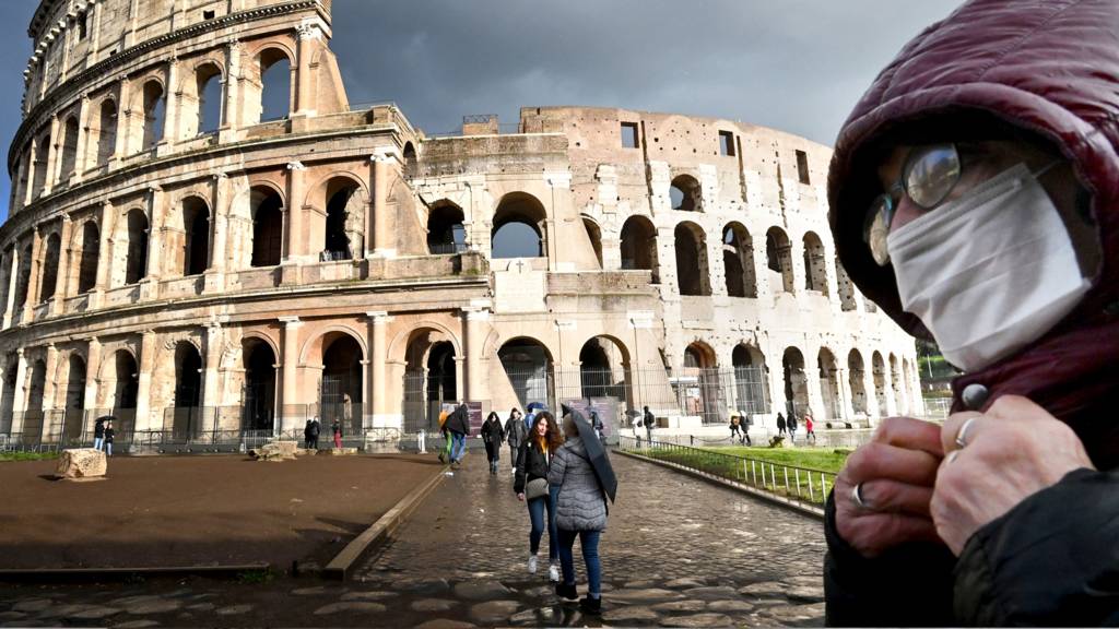 Man wears mask outside coliseum in Rome