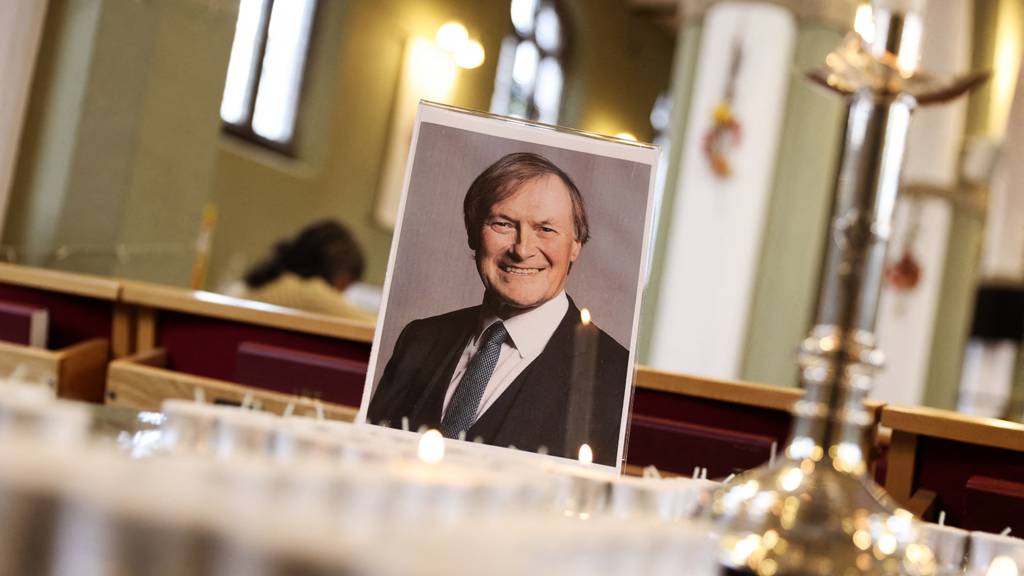 A photograph of Sir David Amess is seen on a table with an arrangement of candles at St Michael's and All Angels Church, Leigh-on-Sea
