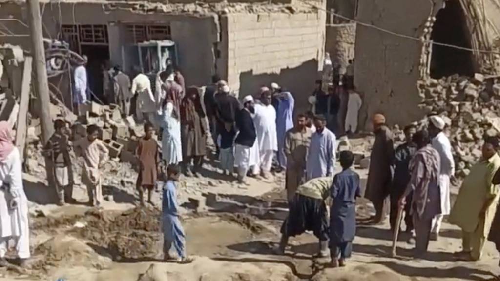 People gather near rubble in the aftermath of Pakistan's military strike on an Iranian village