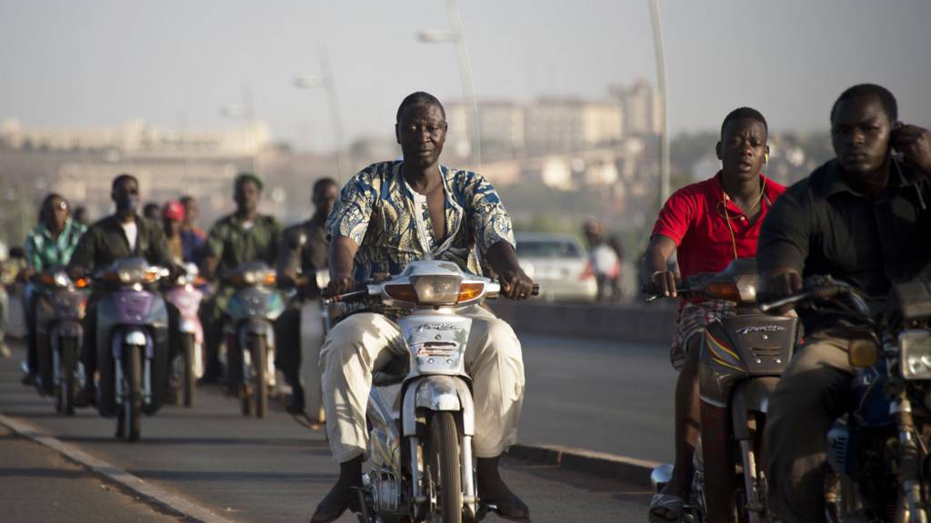 People riding over a bridge in Mali's capital, Bamako - archive shot