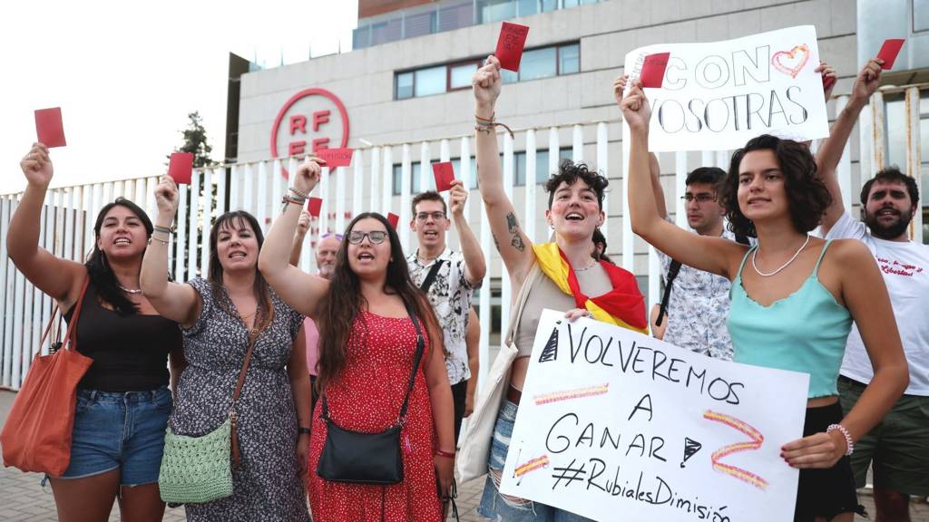 Protesters hold up red cards outside the Spanish football federation