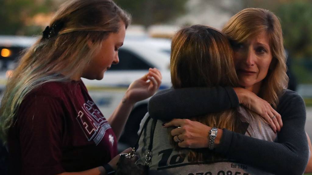 Kristi Gilroy (R), hugs a young woman at a police check point near the Marjory Stoneman Douglas High School