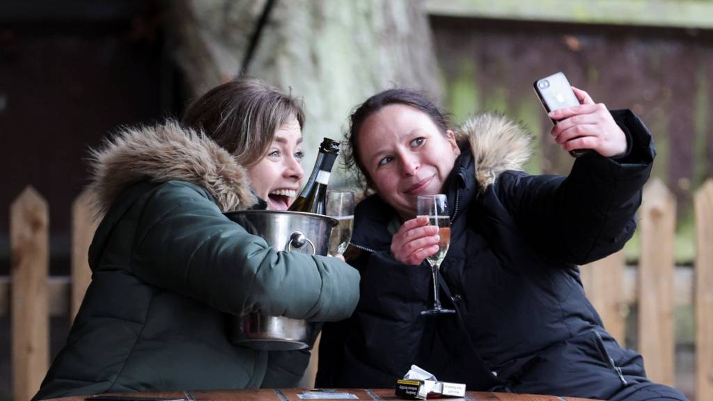 Women take a selfie with their drinks at The Fox on the Hill pub after its reopening, as the coronavirus restrictions ease, in London
