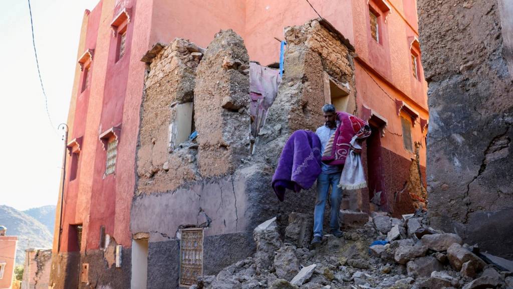 A man carries belongings out of his damaged house, in the aftermath of a deadly earthquake in Moulay Brahim, Morocco