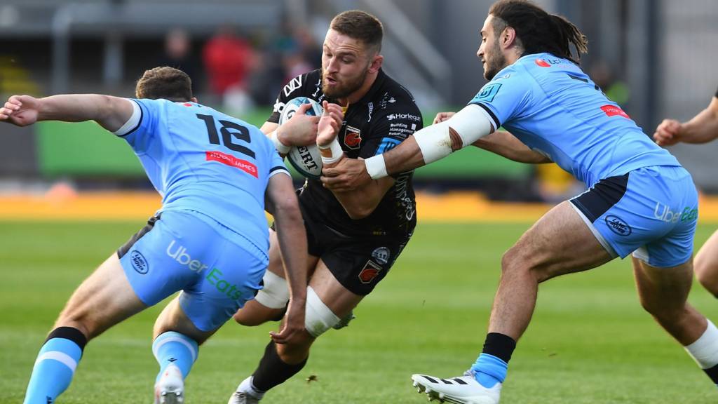 Harri Keddie tries to get pas Max Llewellyn (L) and Josh Navidi