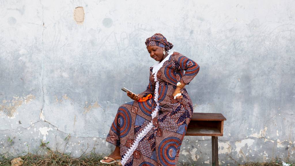 A woman in Lagos, Nigeria, checks her phone