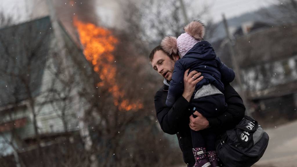 A man and a child escape from the town of Irpin, after heavy shelling on the only escape route used by locals, while Russian troops advance towards the capital of Kyiv, in Irpin, near Kyiv, Ukraine 6 March 2022