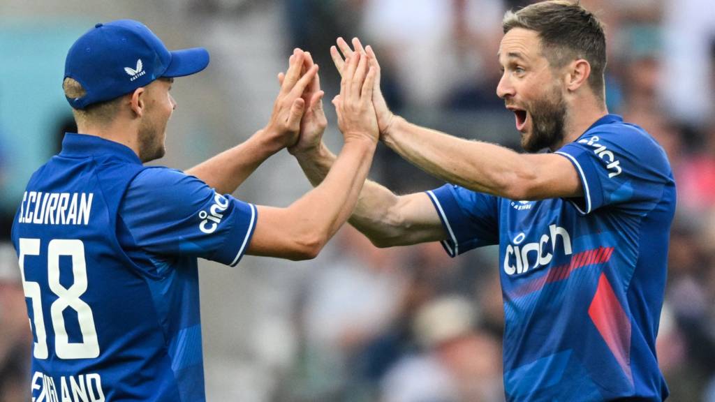 England players Sam Curran (left) and Chris Woakes (right) celebrate a wicket