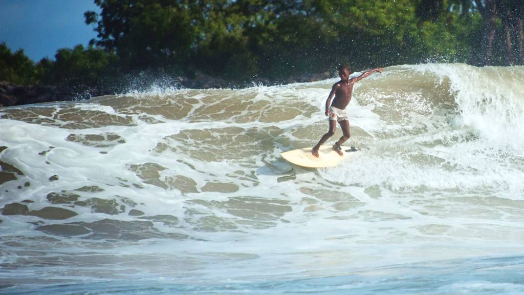 A boy surfing off a beach in Lagos, Nigeria - 2016