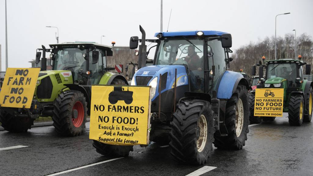 Tractors with signs reading "No Farmers No Food!"