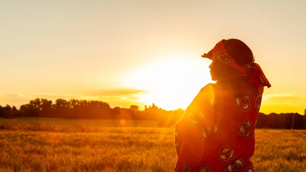 A woman looking at the sun rise in Zimbabwe