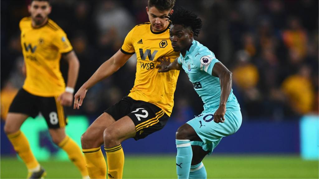 Christian Atsu of Newcastle United holds off Leander Dendoncker