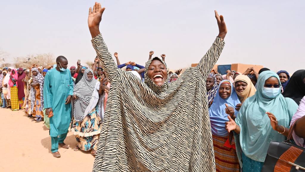 A woman welcoming a guest to a camp in Niger