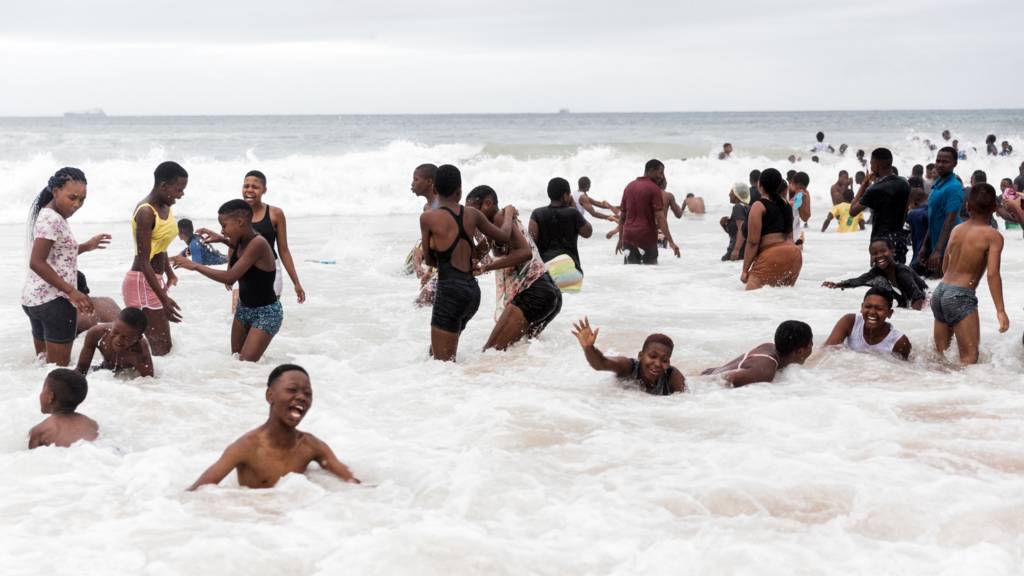People swimming on a beach in Durban, South Africa