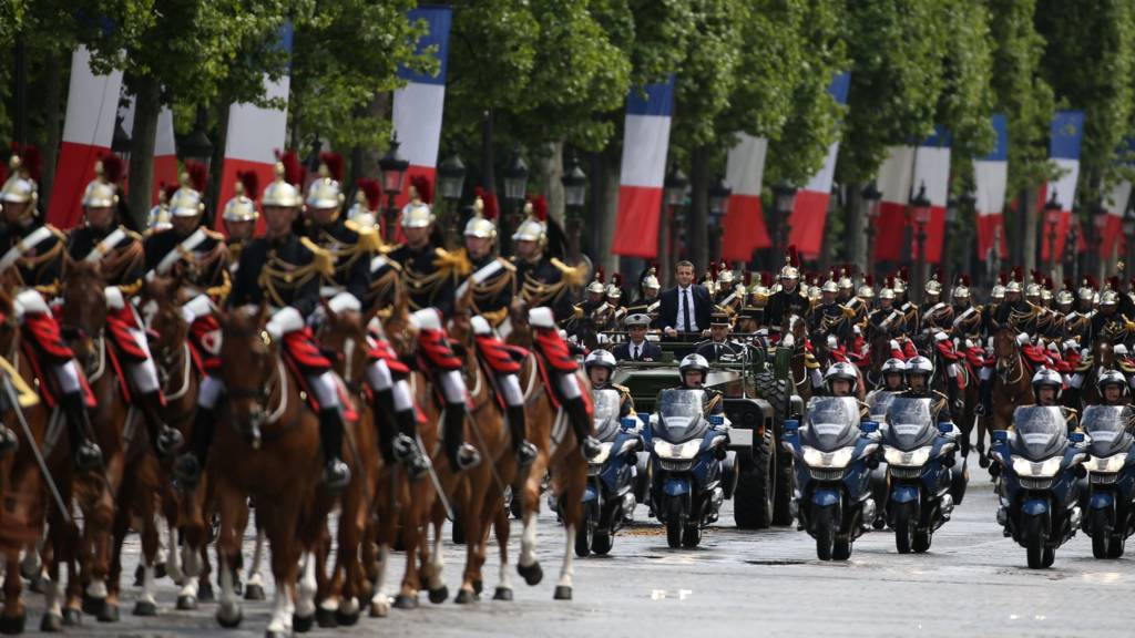 French President Emmanuel Macron (C) parades in a car on the Champs Elysees avenue after his formal inauguration ceremony as French President on May 14, 2017 in Paris.