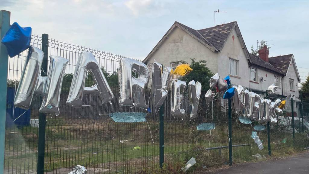 Balloons on fence by way of tribute