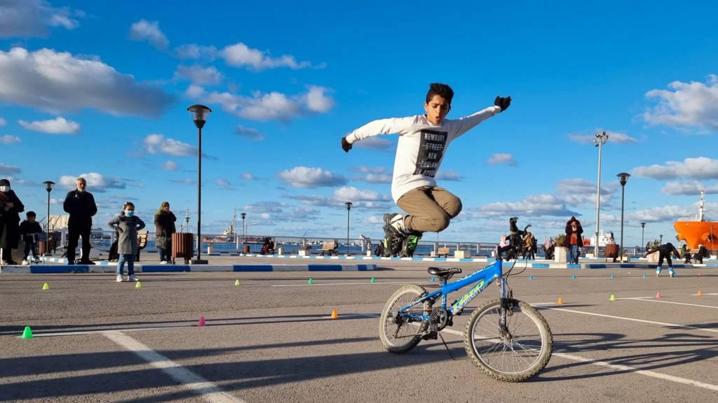 A Libyan youth jumps off his bicycle at the seaside promenade in Libya's capital Tripoli, on February 10, 2022.