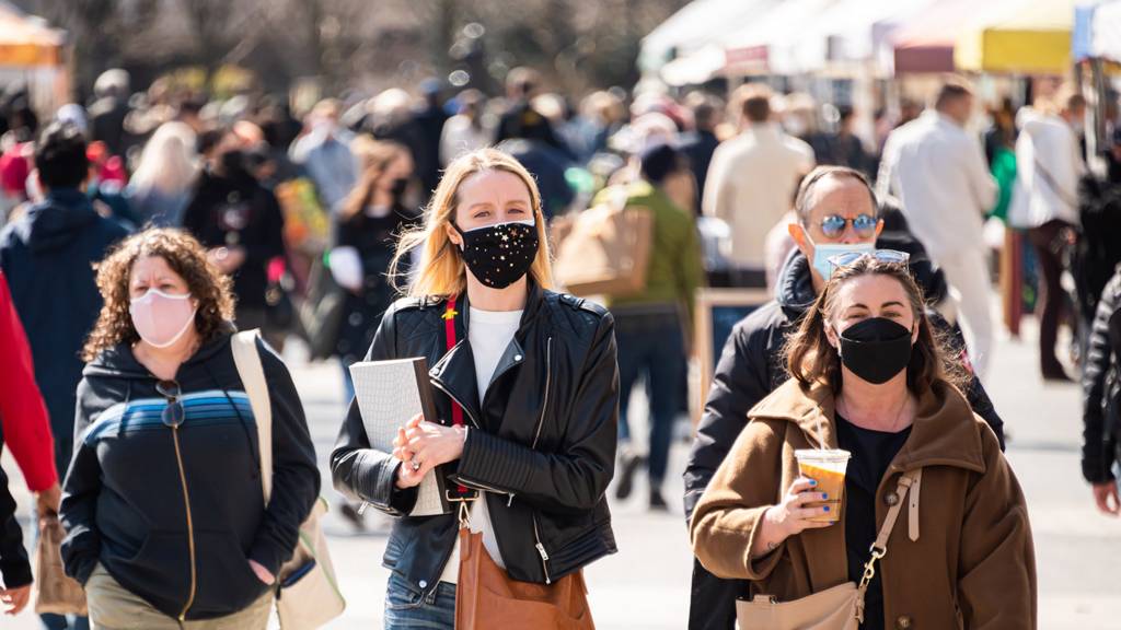 People walking in the street wearing face masks