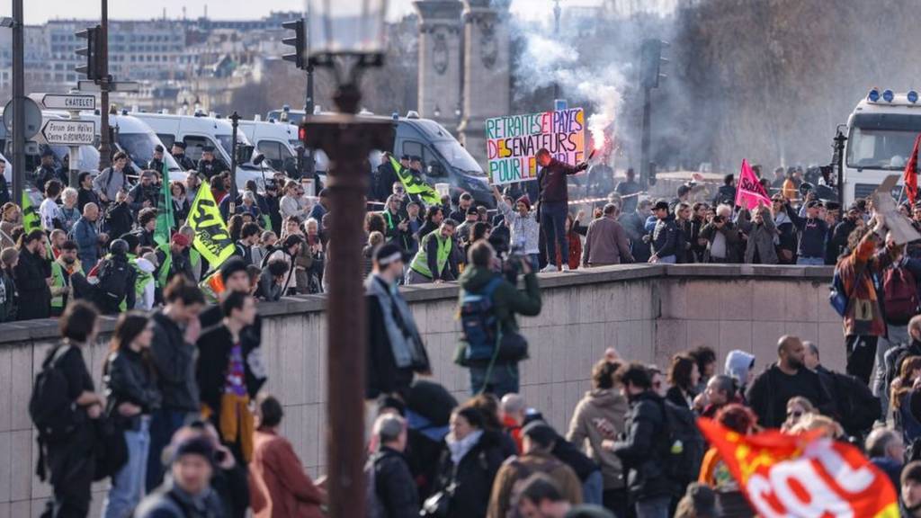 Protesters gather over the exit of a tunnel during a demonstration on Place de la Concorde after the French government pushed a pensions reform through parliament without a vote, using the article 49,3 of the constitution, in Paris on March 16, 2023.