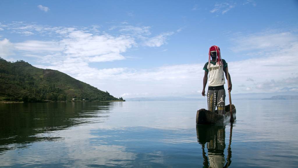 A man standing on a canoe on Lake Kivu just off Idjwi island in the Democratic Republic of Congo - November 2016