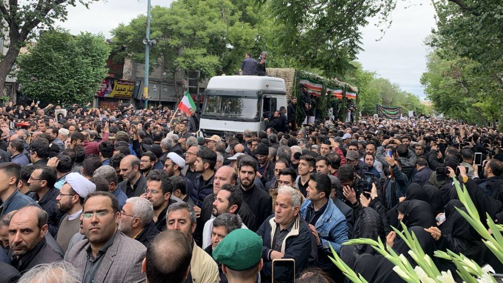 Mourners gather in Tabriz as coffin of late President Raisi is driven through the centre of the street.