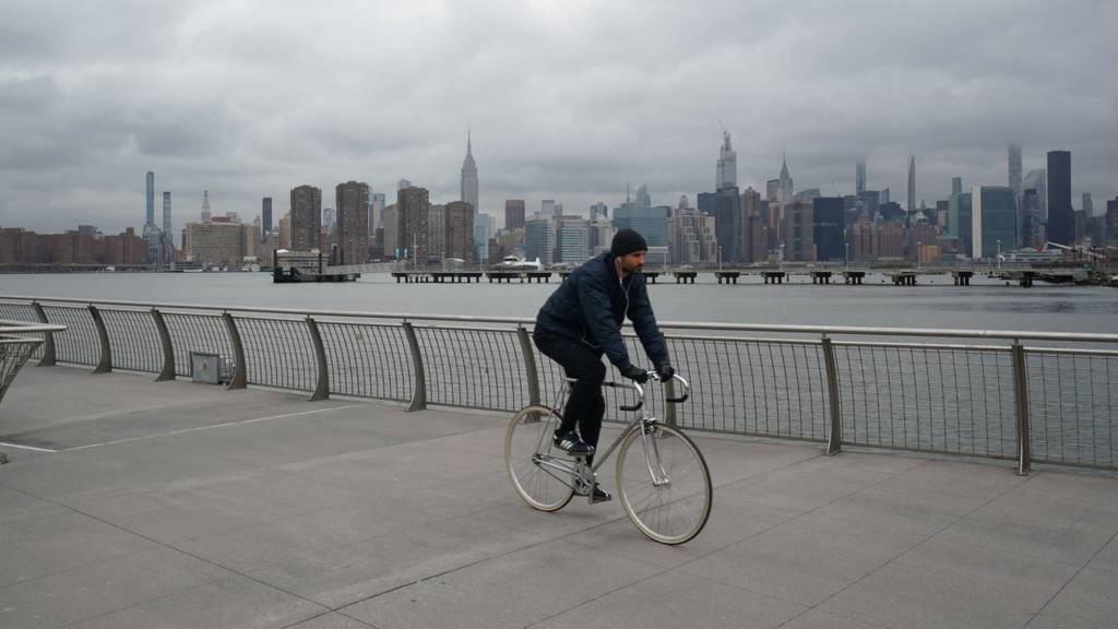 Man cycling with Manhattan in background