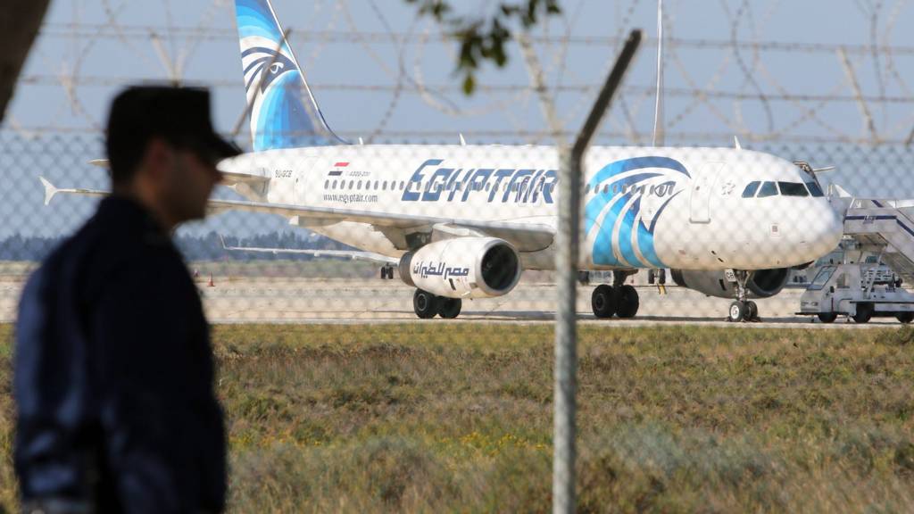 A Cypriot policeman stands guard near a hijacked EgyptAir A320 plane at Larnaca Airport, in Larnaca, Cyprus, 29 March 2016