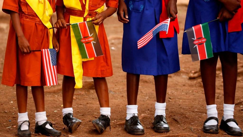 Girls hold Kenyan and US flags