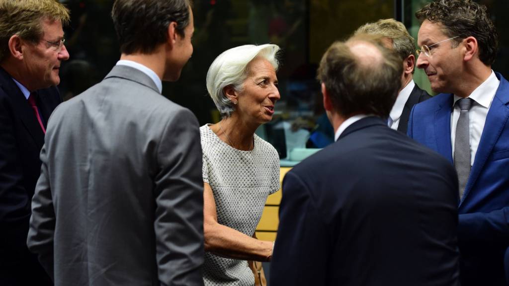 Managing Director of the International Monetary Fund (IMF) Christine Lagarde (C) greets President of the Eurogroup Jeroen Dijsselbloem (R) prior to a meeting of the Eurogroup finance ministers